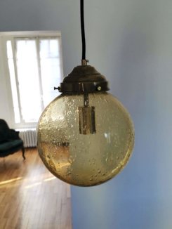 Suspension globe verre bullé de couleur ambrée avec griffe en laiton